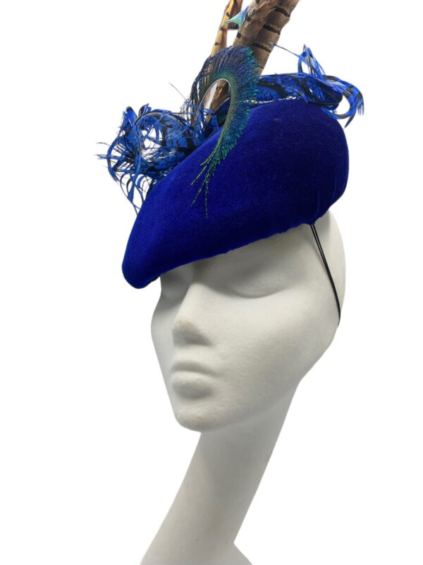 Blue velvet teardrop headpiece, finished with an array of coloured feathers.